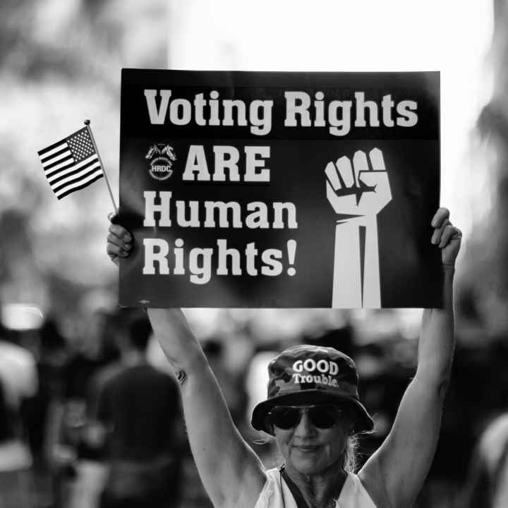 Woman holding sign that says "Voting Rights are Human Rights"
